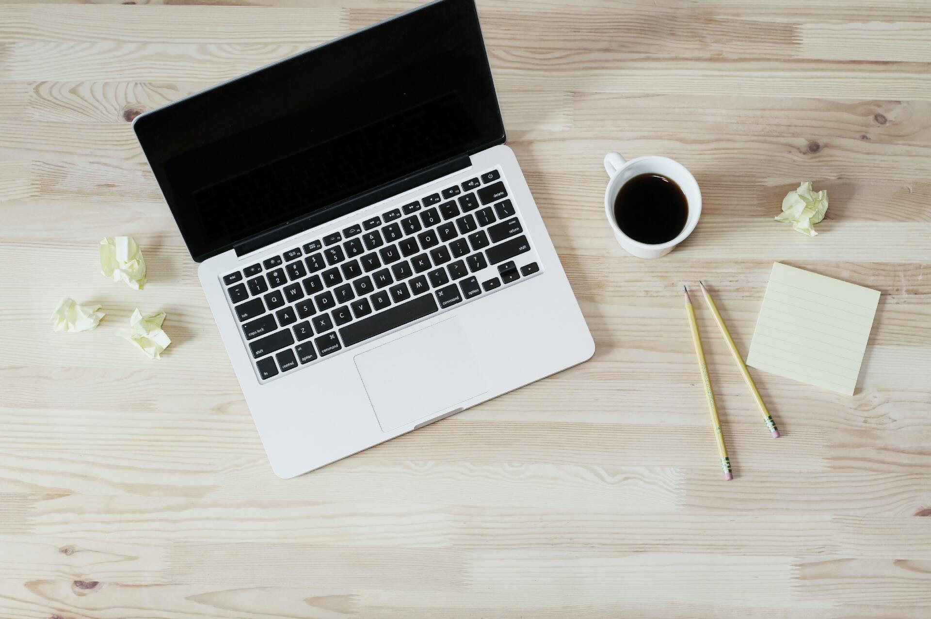 Workstation with a laptop, cup of coffee, and pens