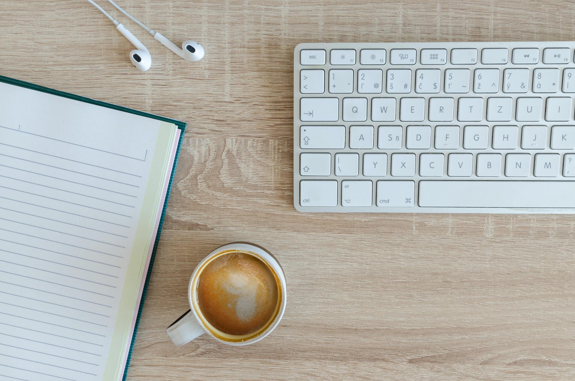 Workstations with laptops, cup of coffee, and pens