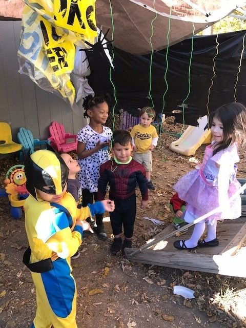 A group of children dressed in costumes are playing outside