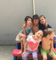 A group of children are sitting on a bench.