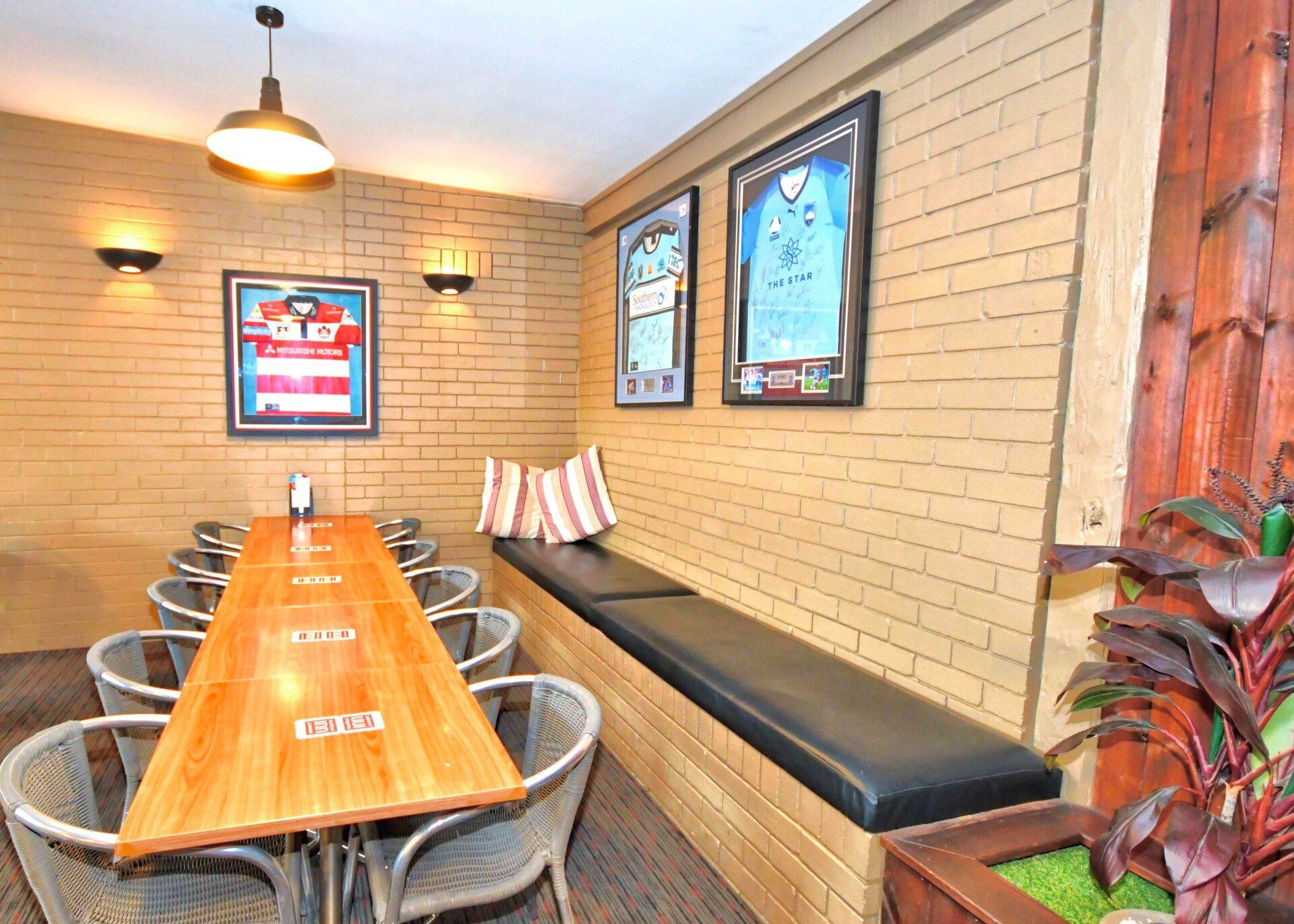 A Long Wooden Table and Chairs in A Room with A Brick Wall — Roundabout Inn in Gloucester, NSW