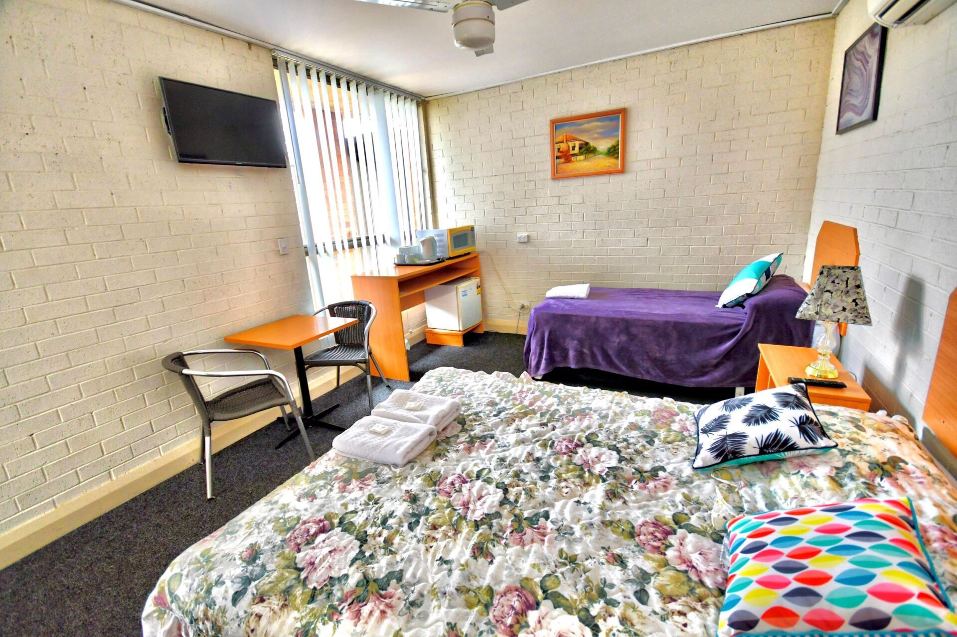 A Hotel Room with Two Beds , a Table and A Television — Roundabout Inn in Gloucester, NSW