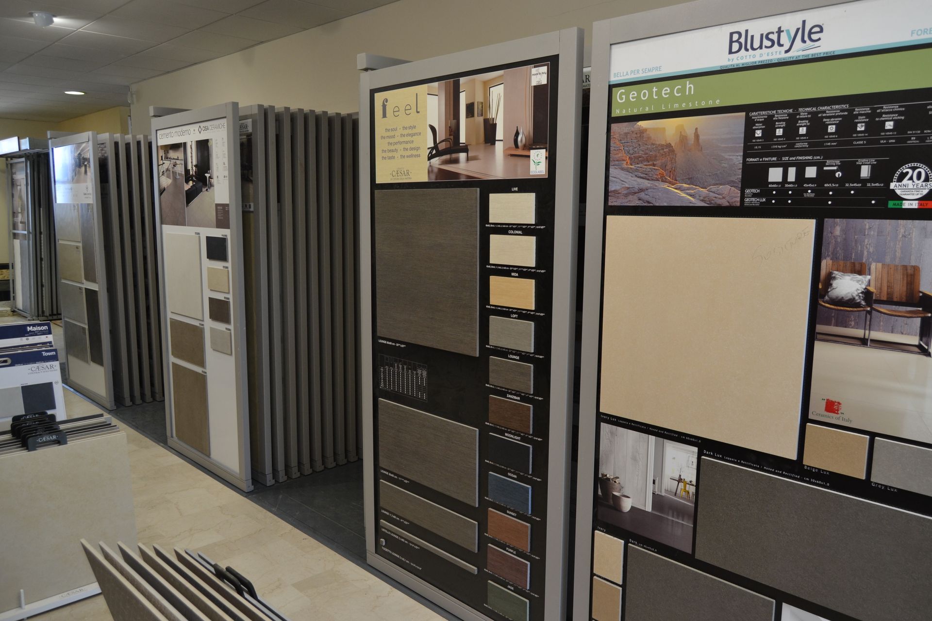 Tile display in a showroom, featuring various tile samples arranged on panels with different colors and textures.