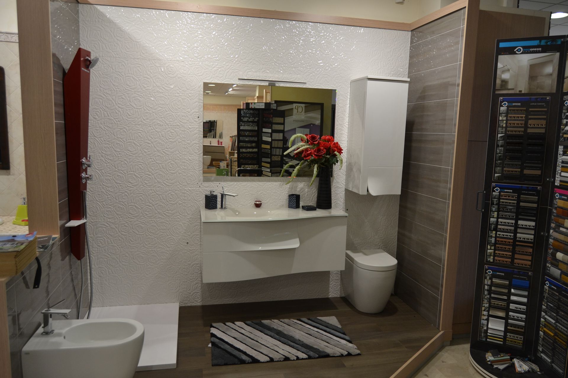 Bathroom display with white sparkly wall tiles, modern fixtures, and wooden floor.