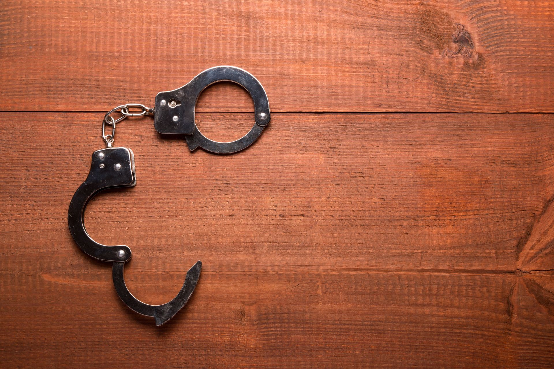 A pair of handcuffs sitting on top of a wooden table.