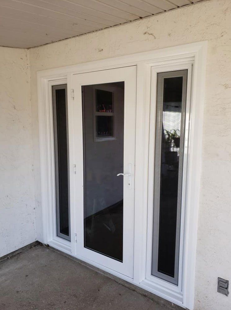 A white door with a lot of windows is sitting on a patio.