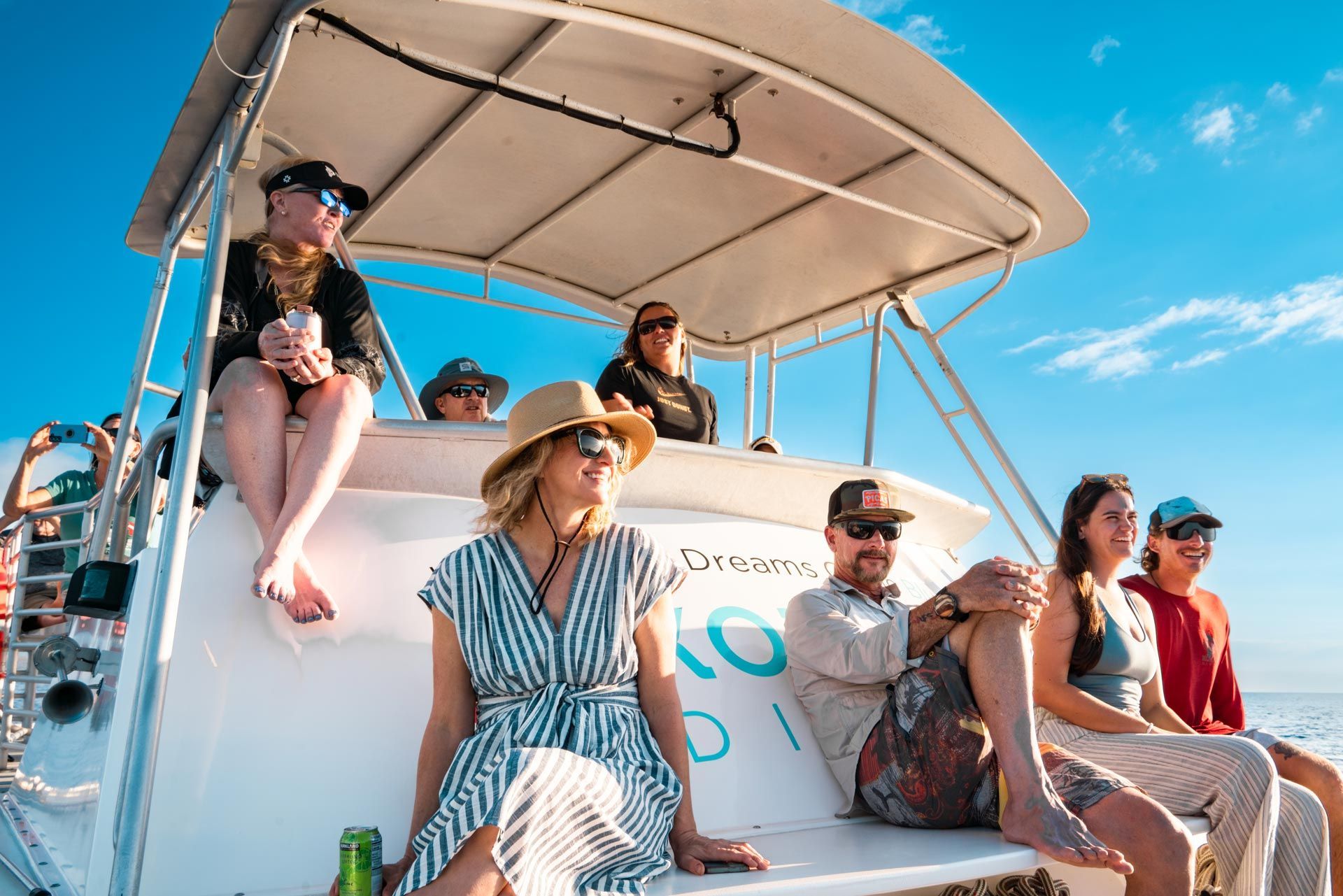 A group of people are sitting on the back of a boat.