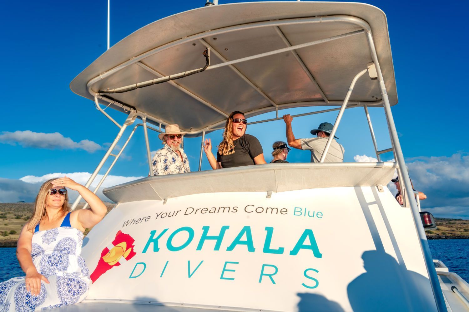 A group of people are sitting on the back of a boat.
