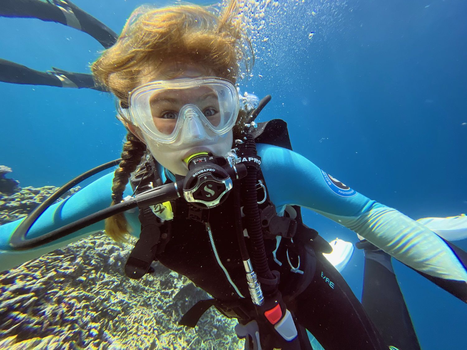 A woman is scuba diving in the ocean.