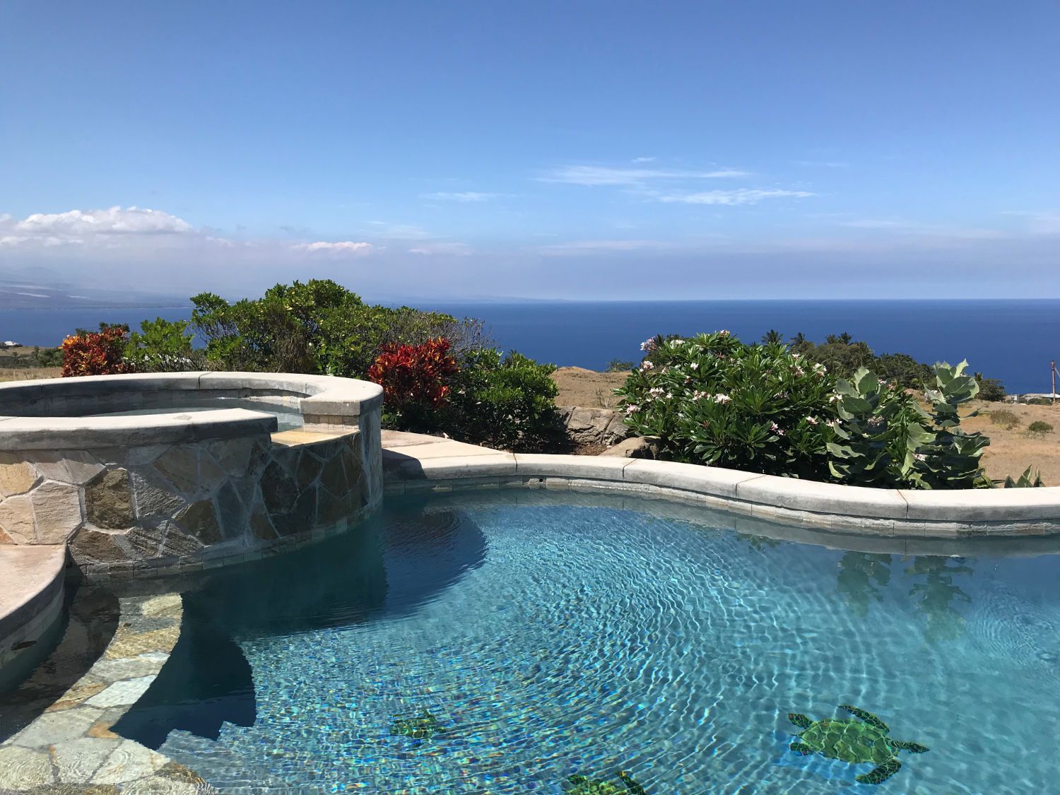 A large swimming pool with a view of the ocean.