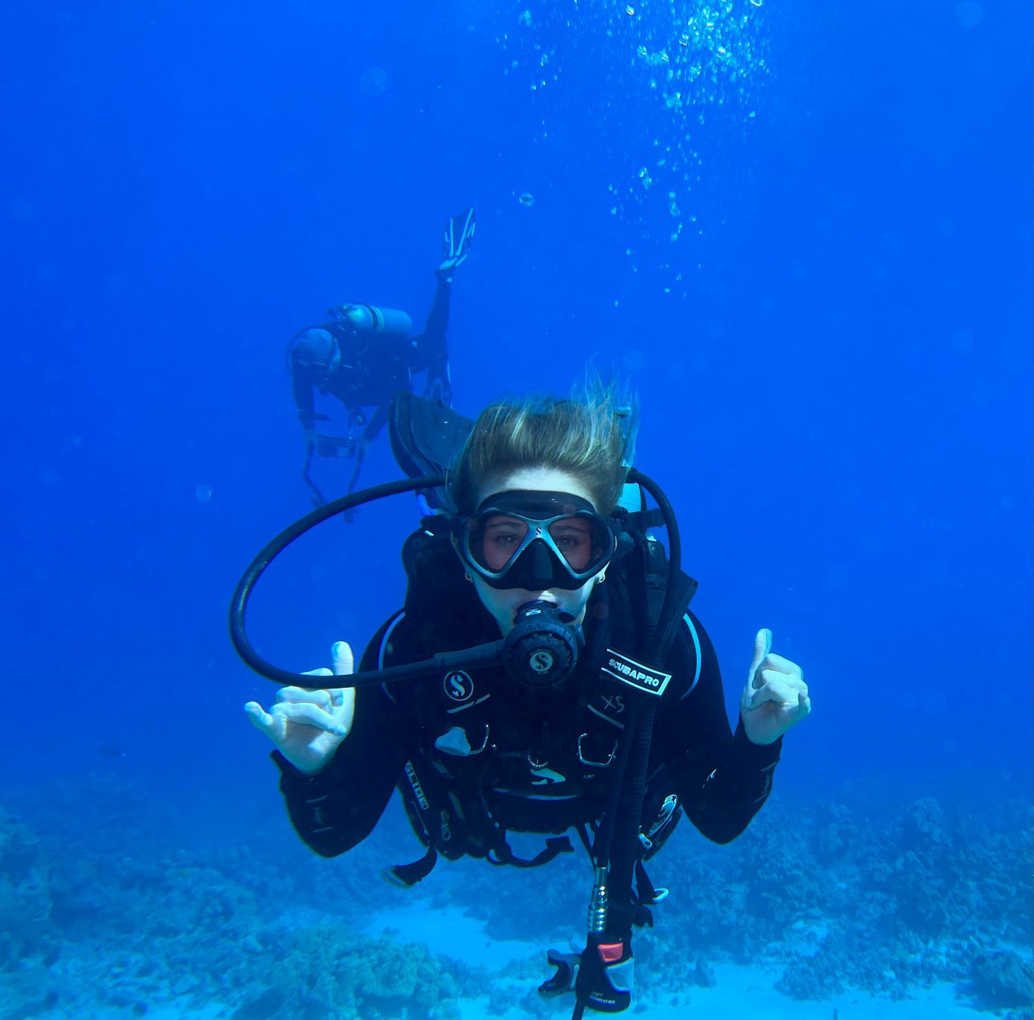 A scuba diver is giving a thumbs up in the ocean