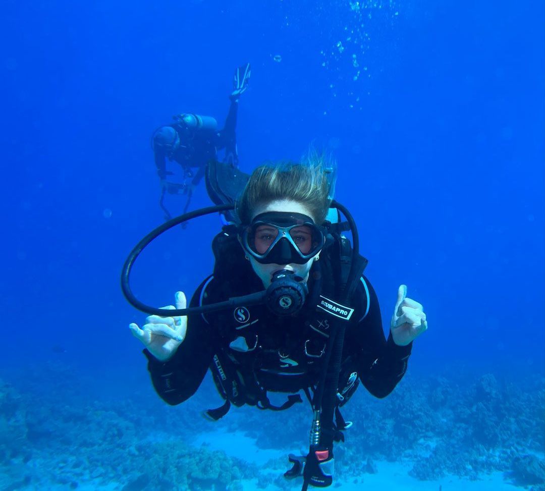 A scuba diver is giving a thumbs up in the ocean