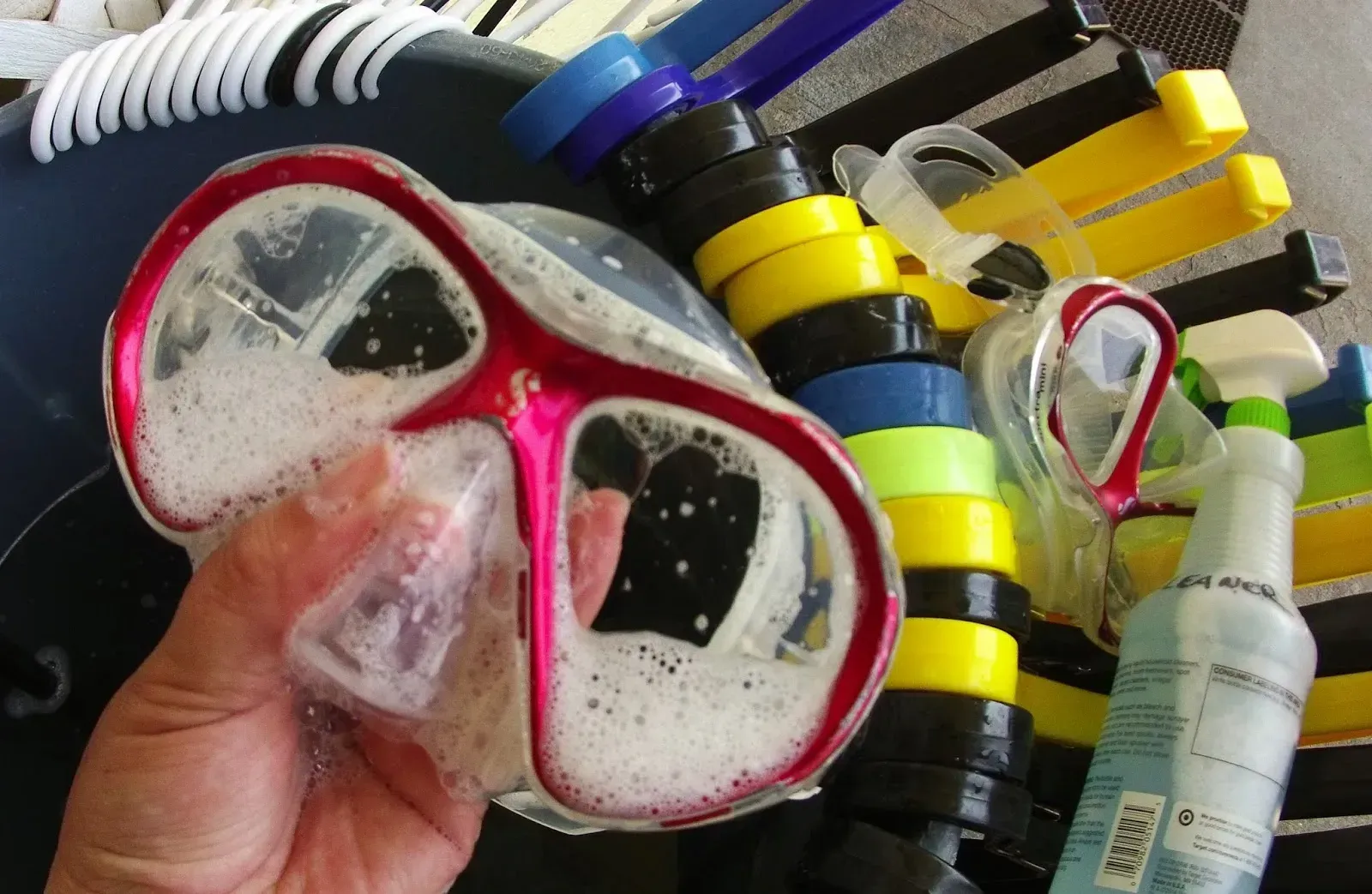 A person is holding a pair of goggles in their hand