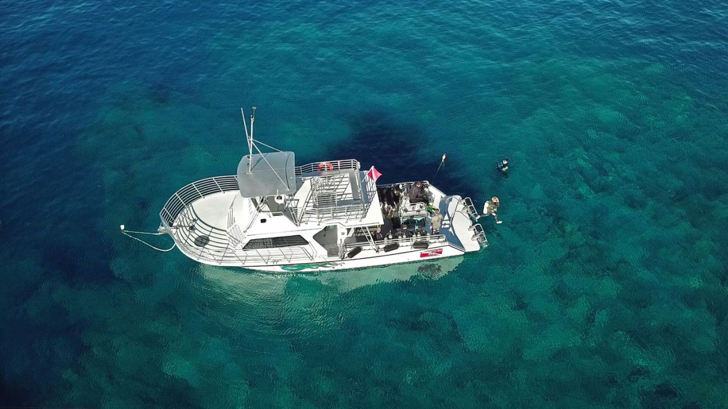 An aerial view of a boat in the middle of the ocean.
