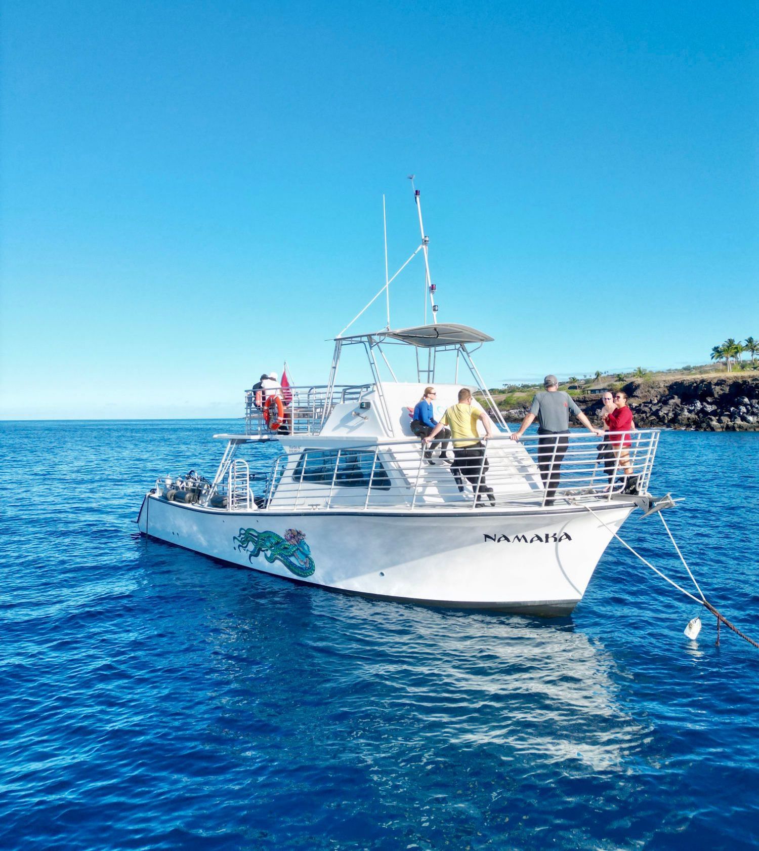 A group of people are on a boat in the ocean.