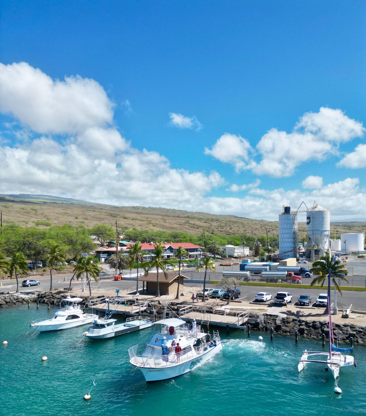 A group of boats are docked in a harbor on a sunny day