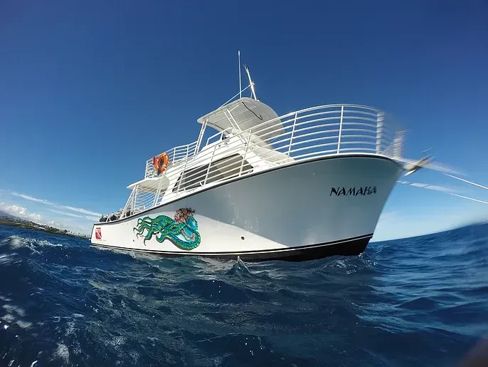 A large white boat is floating on top of a large body of water.