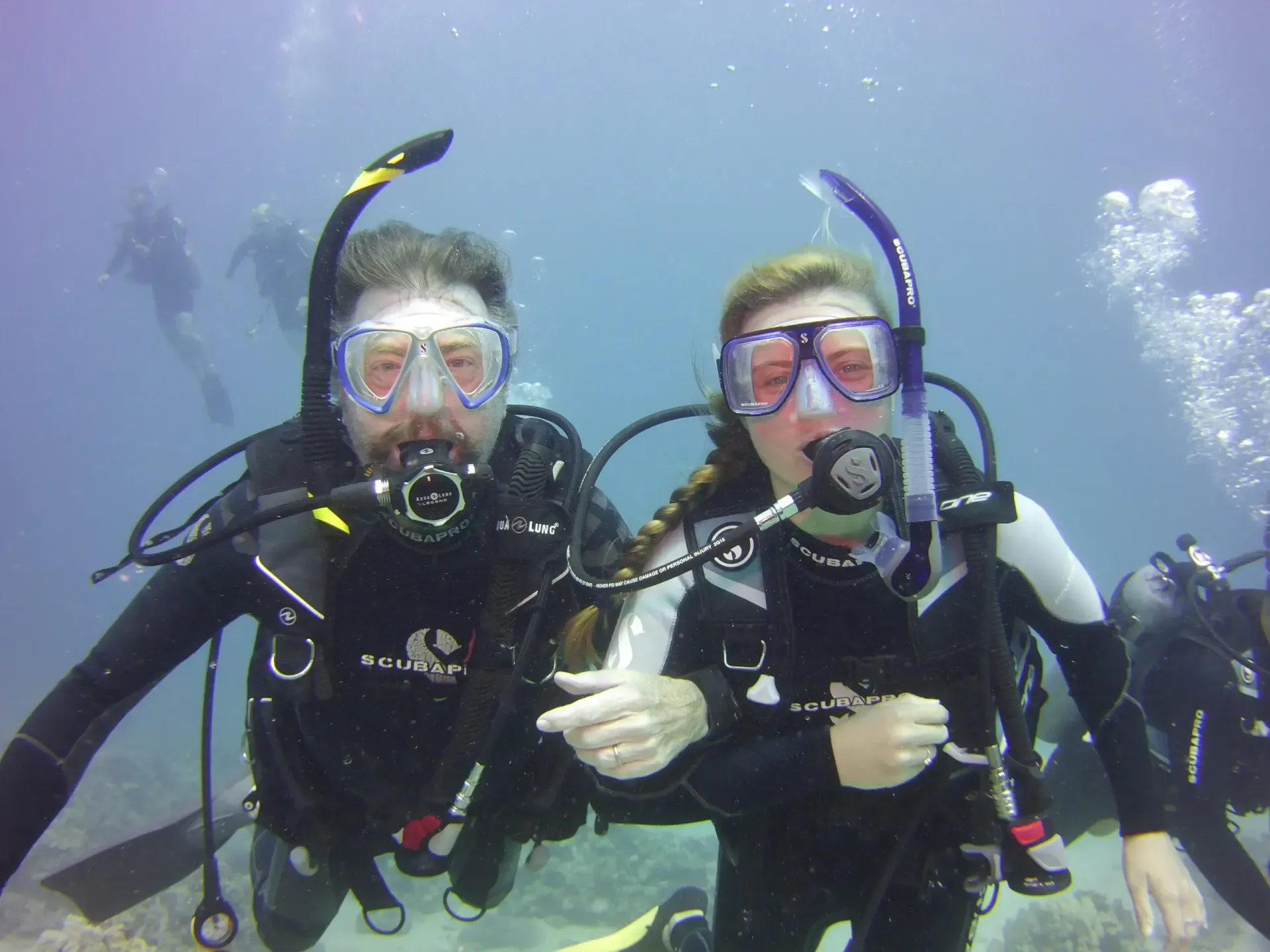 A man and a woman are scuba diving in the ocean