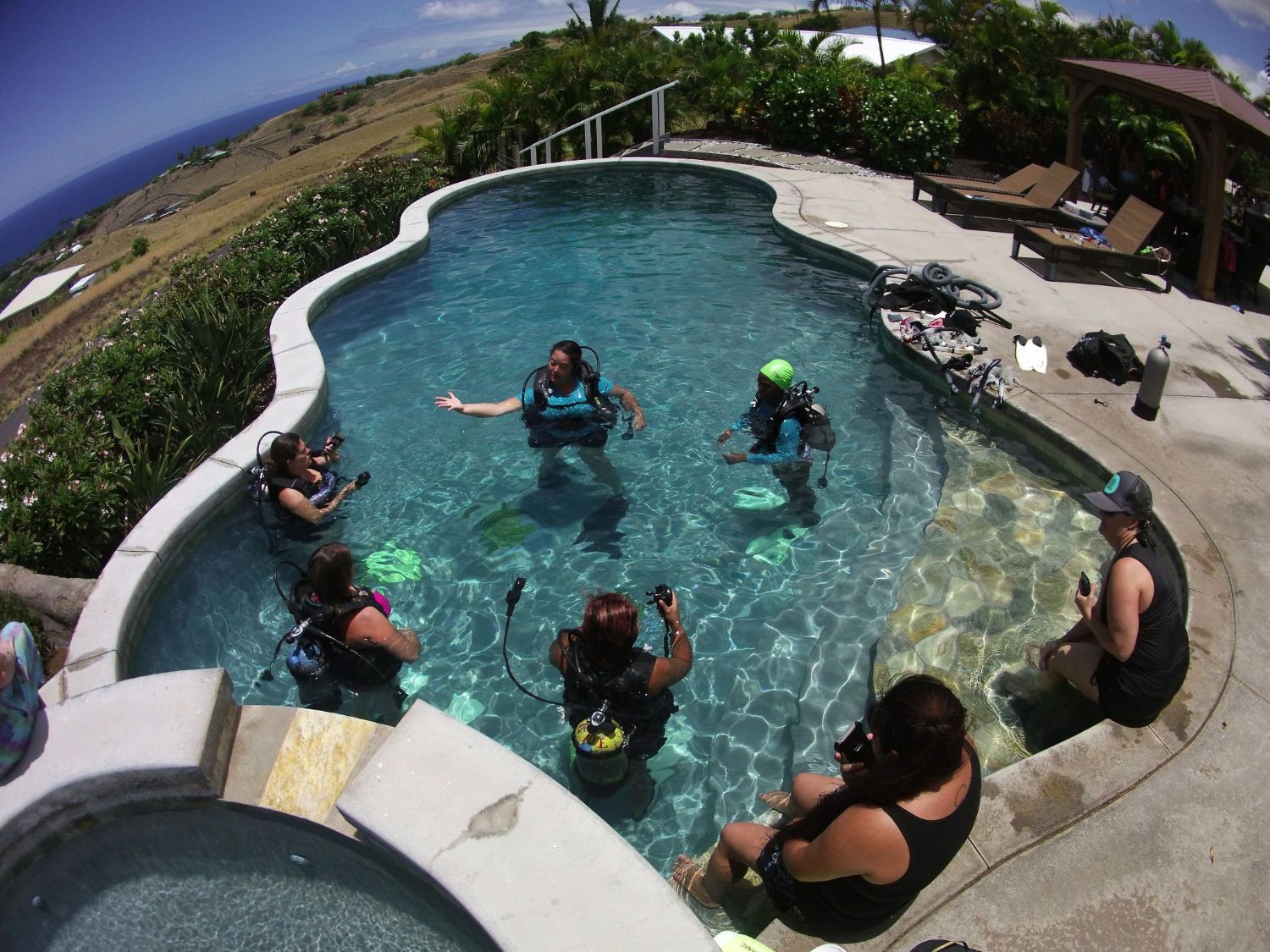 A group of people are learning scuba diving in a swimming pool