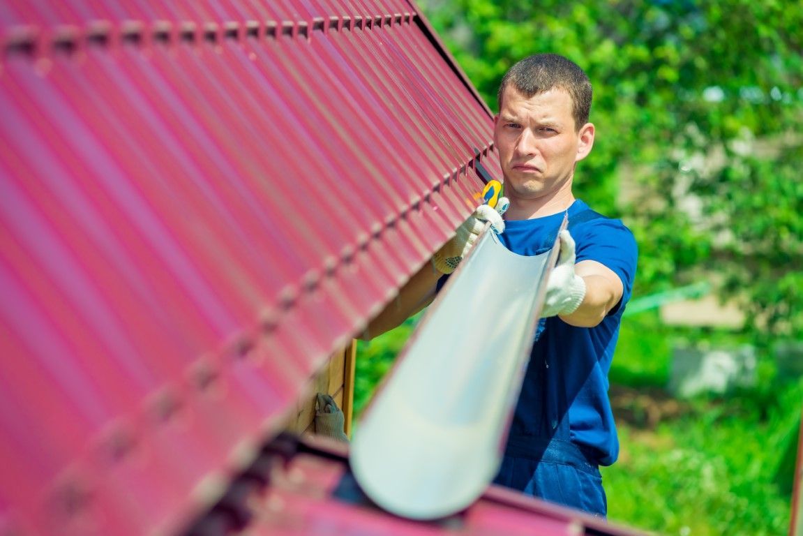Man installing gutters on home