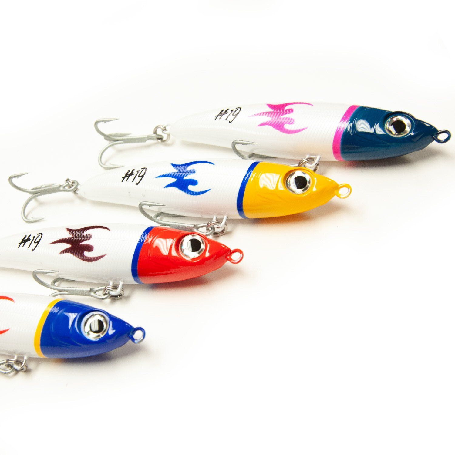Cinco coloridos señuelos de pesca alineados sobre un fondo blanco.