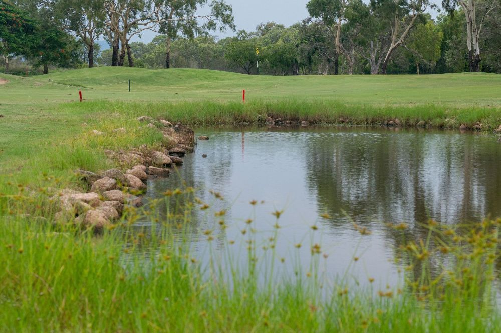 There is a pond in the middle of a golf course— Rowes Bay Golf Club In Rowes Bay, QLD