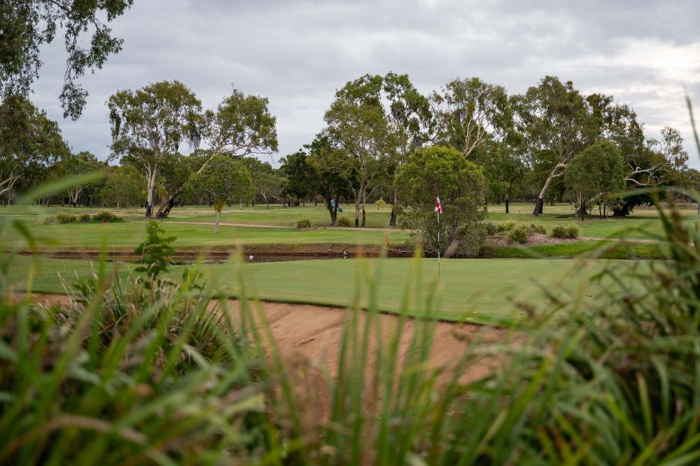 A golf course with trees and grass in the foreground and a pond in the background — Rowes Bay Golf Club In Rowes Bay, QLD