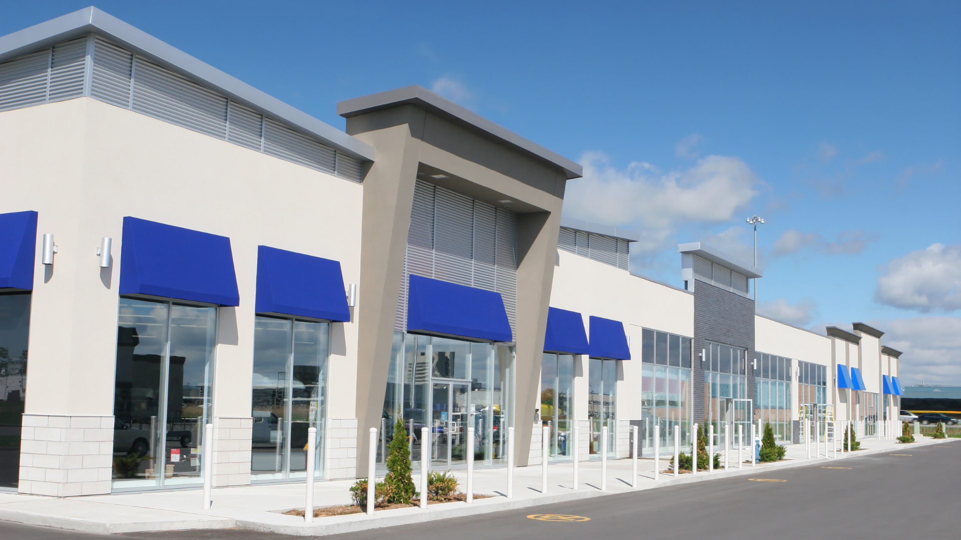 A large white building with blue awnings on the windows.