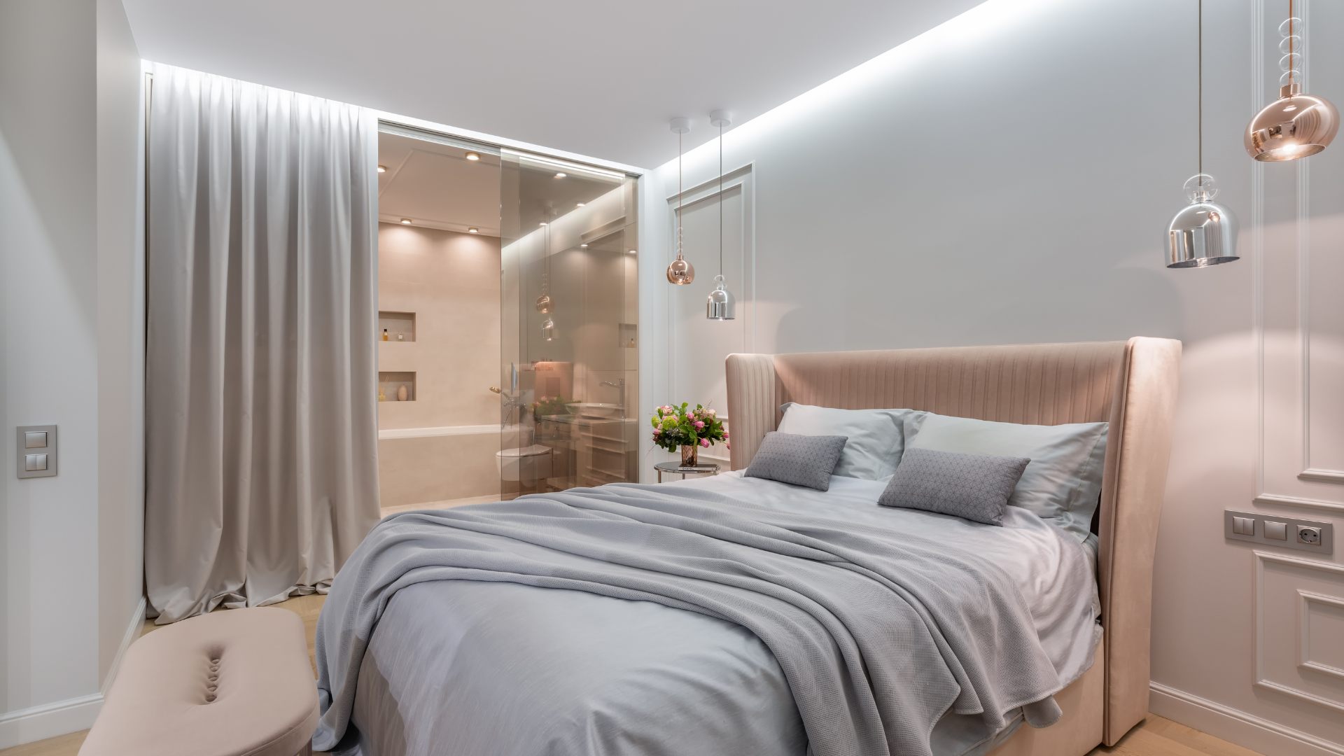 A bedroom with a large bed and a bathroom in the background.