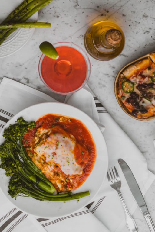 A plate of food and a drink on a table.