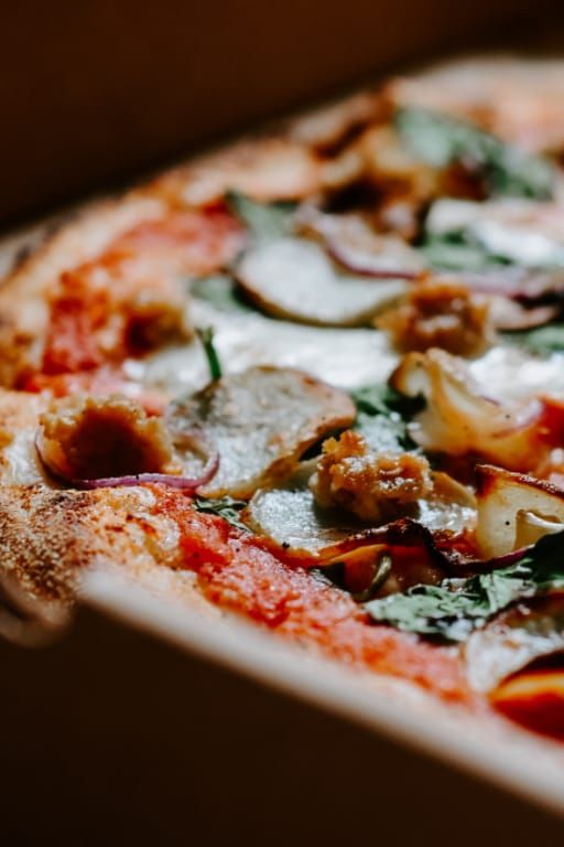 A close up of a pizza in a cardboard box.