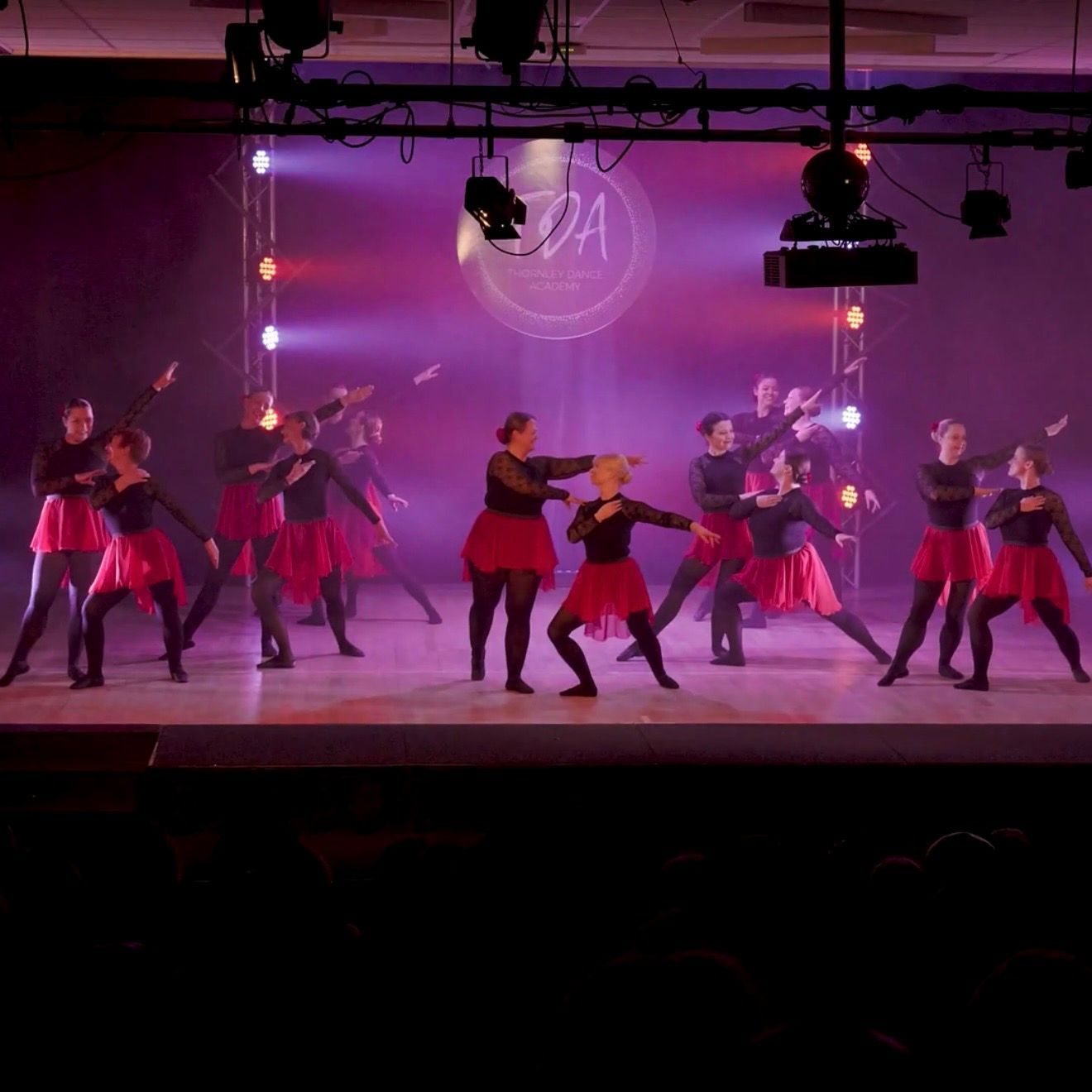 A group of women are practicing ballet on a dance floor