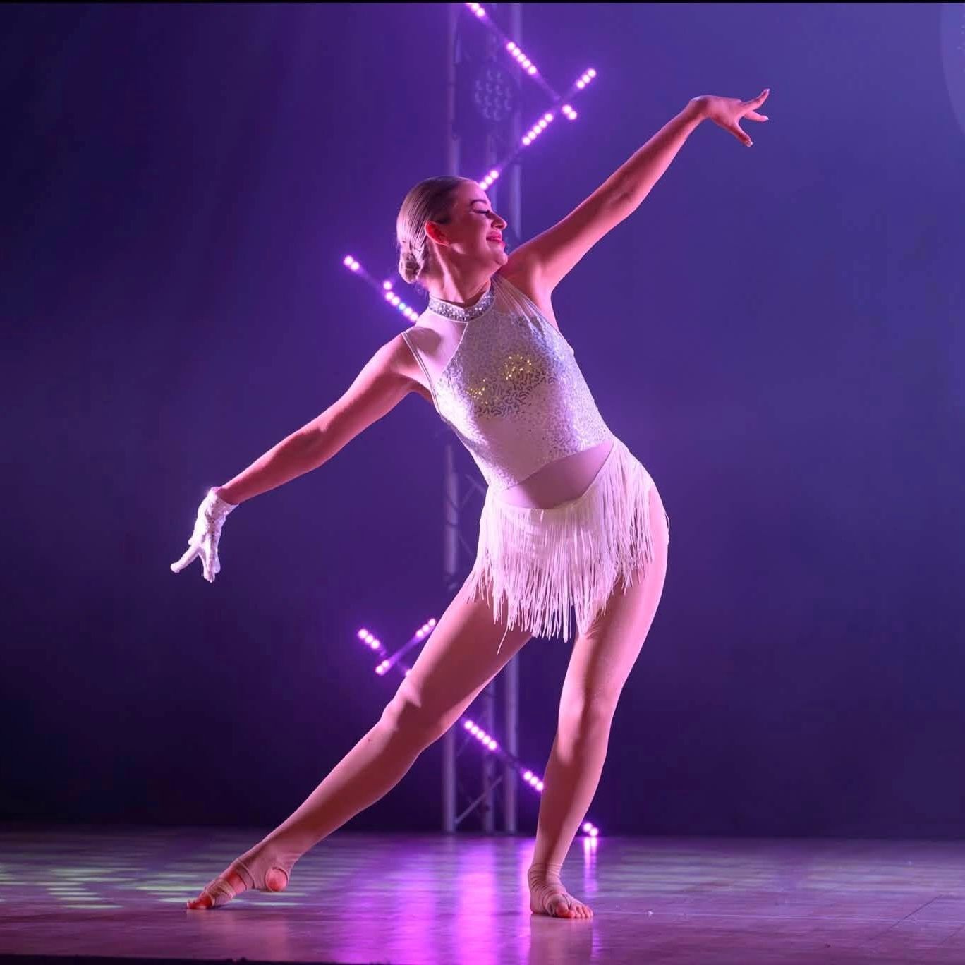 A group of women are practicing ballet on a dance floor