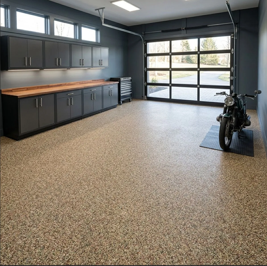 Modern garage with gray cabinets, speckled epoxy floor, and a motorcycle near the open glass door