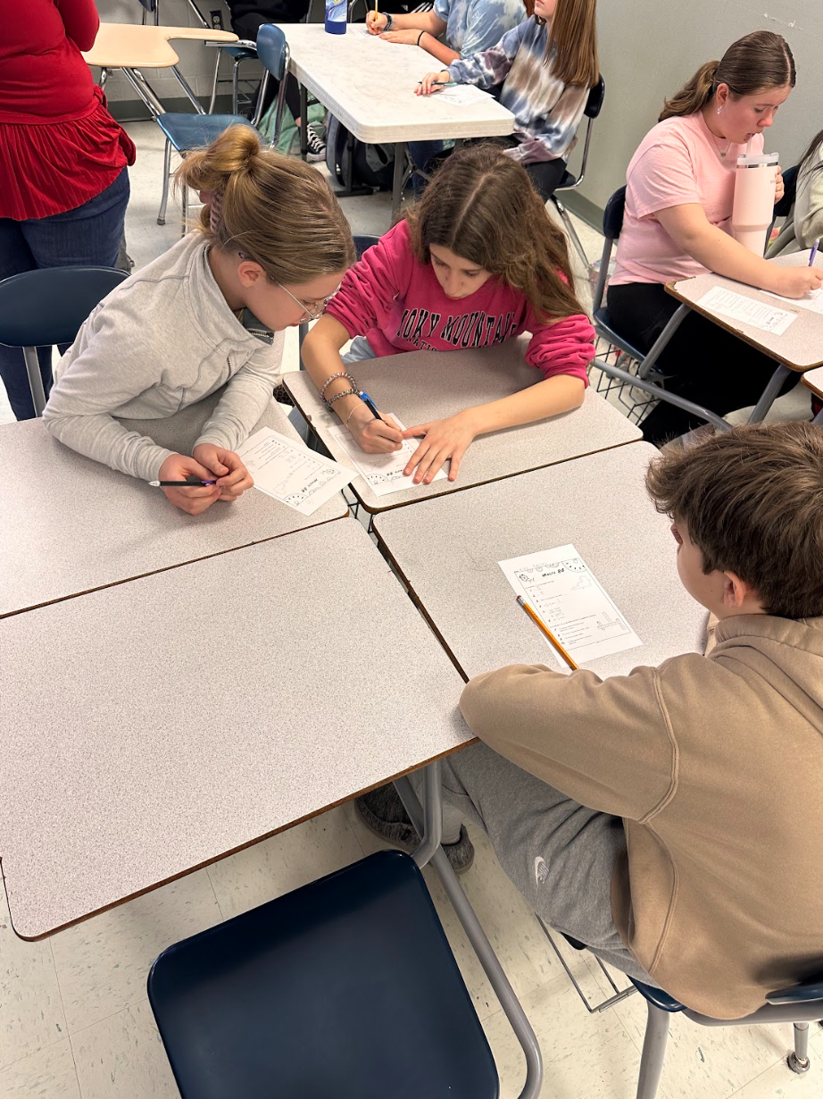 A group of children are sitting at desks in a classroom.