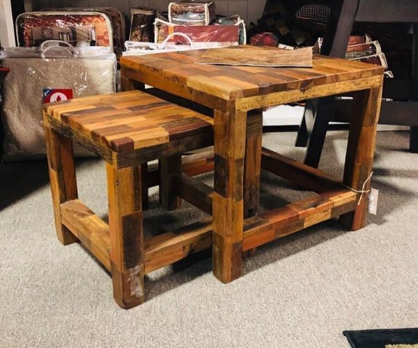 Two rustic wooden stools with a matching tabletop, showing a small nesting table set on carpet.