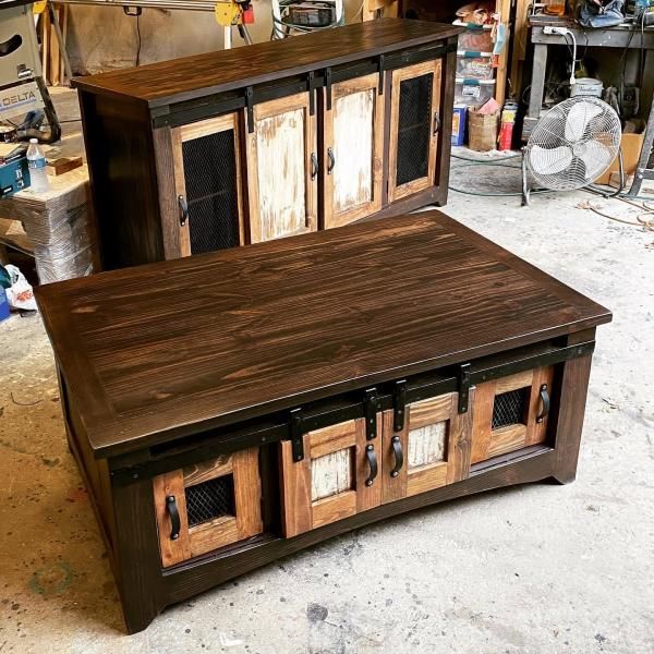 Two handcrafted wooden cabinets with dark tops in a workshop, featuring mixed wood panel doors.