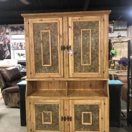 Wooden cabinet with four doors and a lower open shelf, in a furniture showroom.