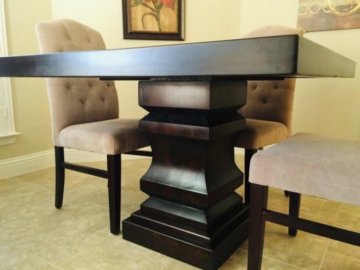 Dark wooden dining table with upholstered chairs in a bright dining room