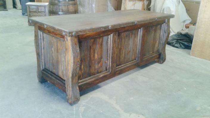 Rustic wooden chest with a flat top, shown in a workshop or storage area.
