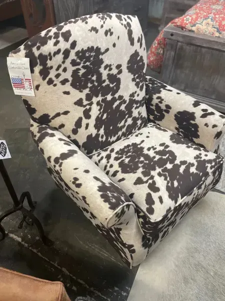 Cowhide-patterned upholstered armchair in a store setting