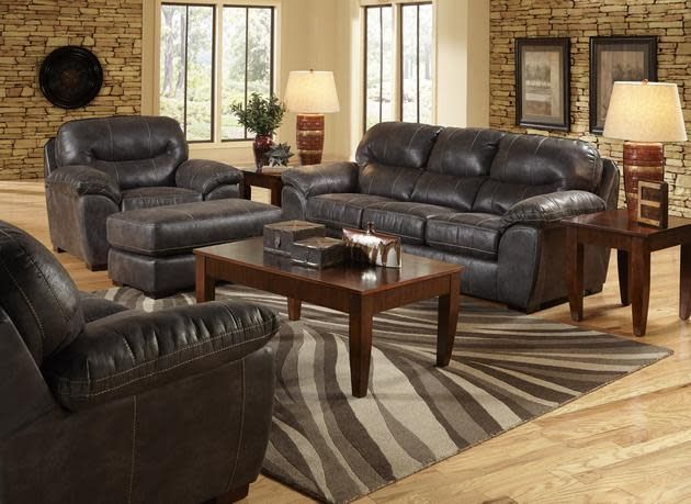 Living room with dark leather sofa, recliner, coffee table, lamp, and sunburst rug
