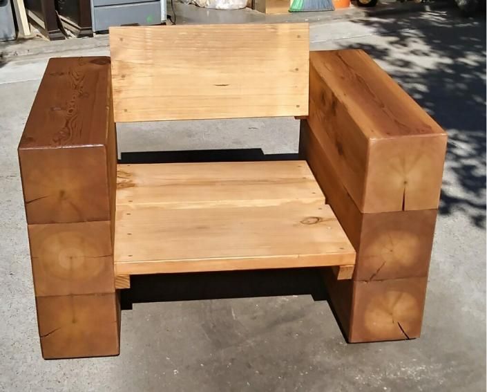 Wooden armchair made from stacked logs with a simple slatted seat and backrest outdoors