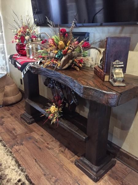Decorated wooden console table with autumn floral arrangements in a home entryway