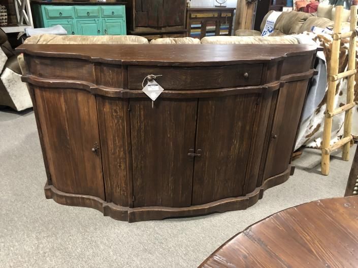 Dark wooden curved bar cabinet with a diamond-shaped latch in a workshop setting.