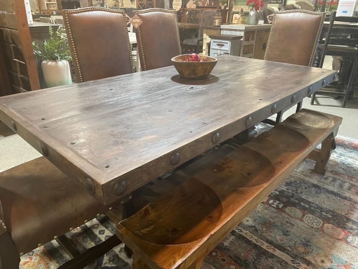 Rustic wooden dining table with a bowl centerpiece in a cozy restaurant setting