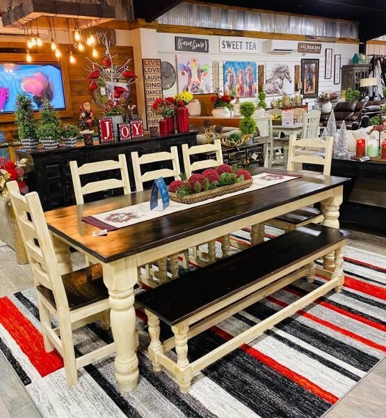 Rustic dining room display with white benches, striped rug, farmhouse table, and holiday decor on shelves