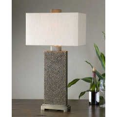 Modern table lamp with white shade and textured dark base on a wooden surface