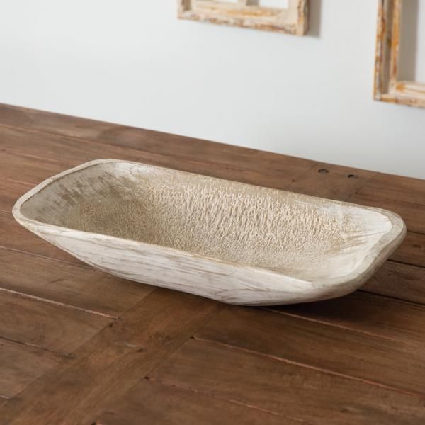 Textured oval white serving bowl on a wooden table.