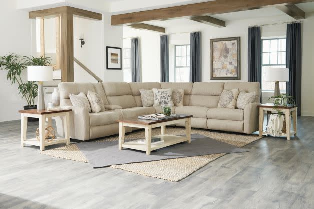 Beige sectional sofa in a bright living room with wood beams, matching coffee table, and light gray floors